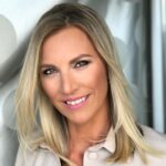 Portrét usmievajúcej sa ženy Barbora Chárová s blond vlasmi na neutrálnom pozadí
